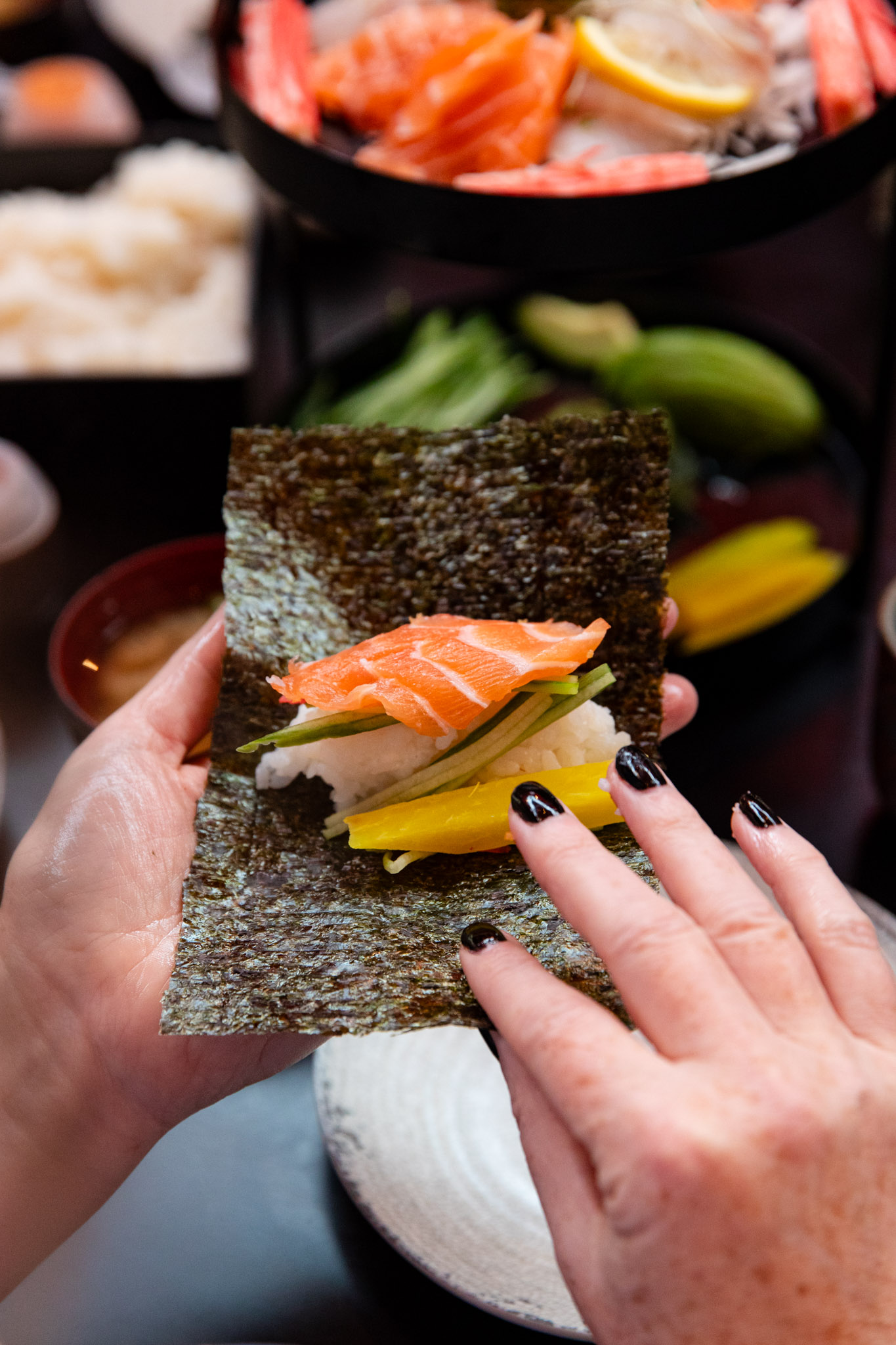 two hands about to roll a temaki sushi